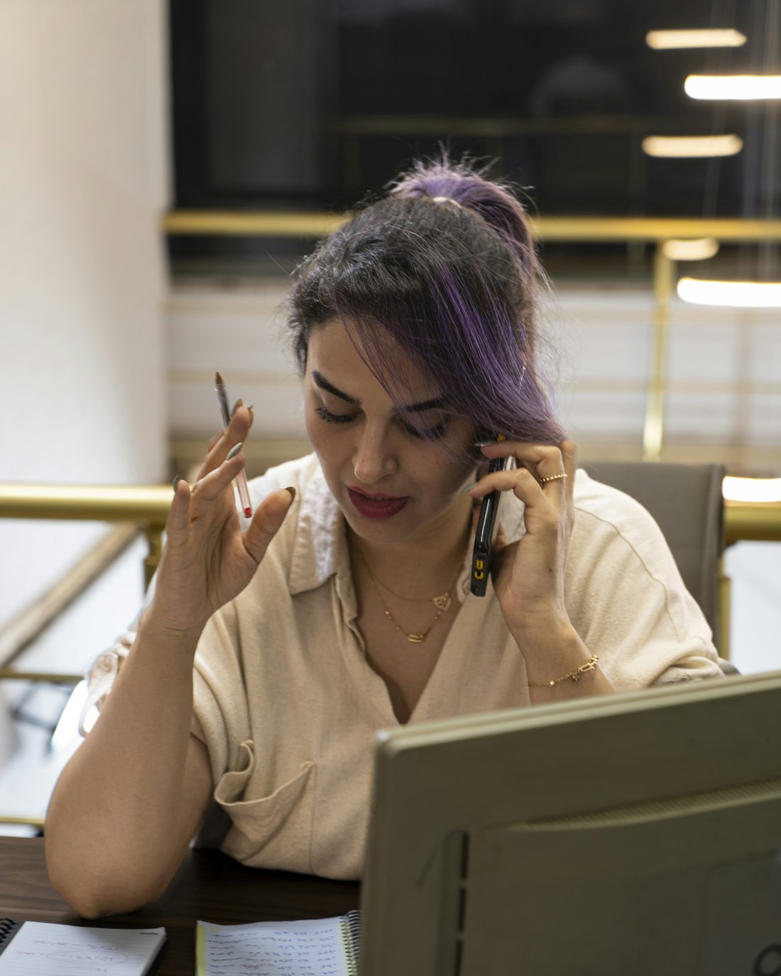 Jonge professional appt op de telefoon aan een bureau